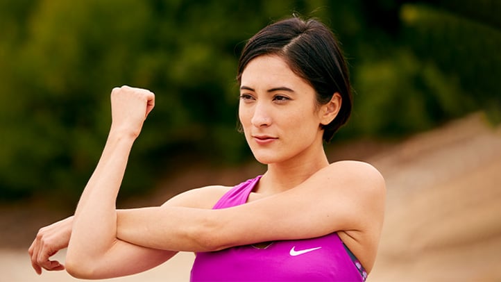 Woman stretching shoulder/arm outside