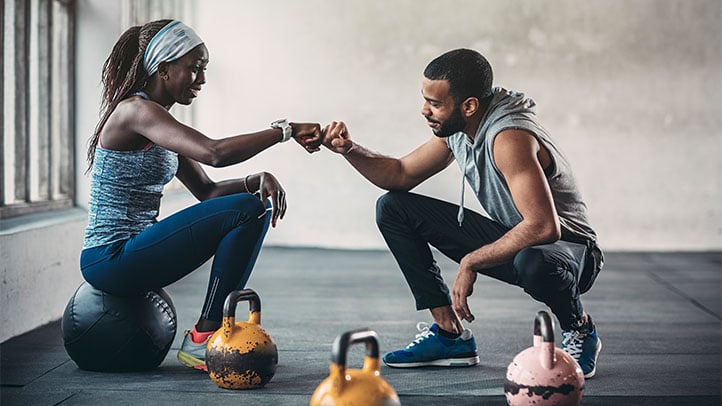 Two athletes fist bumping