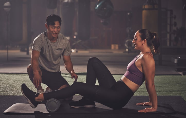 trainer helping client with corrective exercise techniques 