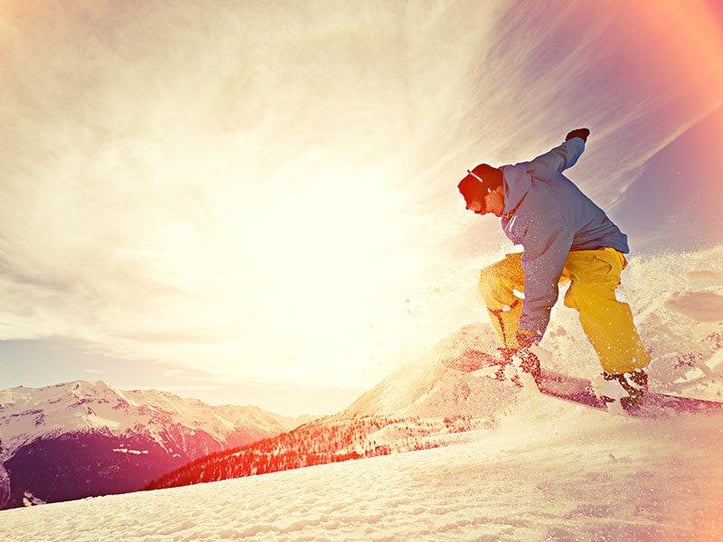 snowboarder doing trick on snowy mountain